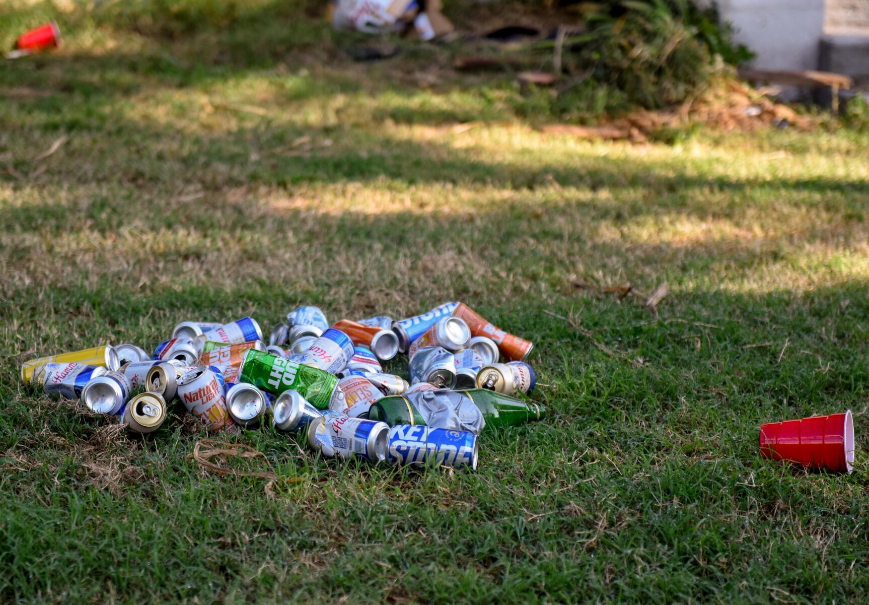 Empty beer cans, plastic cups and an empty 40-ounce alcohol bottle lay in a pile in the front yard